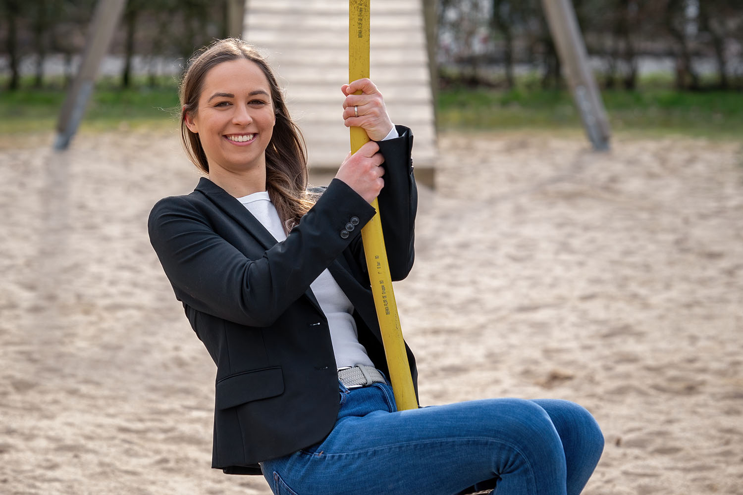 Die Bürgermeisterkandidatin zeigt sich dynamisch und nahbar: Mit einem Lächeln nutzt sie spielerisch die Seilbahn auf einem Spielplatz – ein Moment voller Energie und Lebensfreude